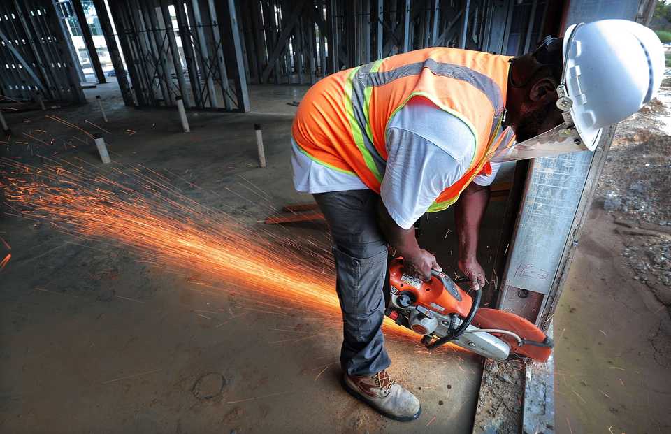 <strong>Contractor Javonte Johnson finishes cutting out door frames as construction continues on a Hilton Garden Inn, part of a dual-hotel complex at the $90 million TraVure mixed-use project in Germantown. </strong>(Jim Weber/Daily Memphian)